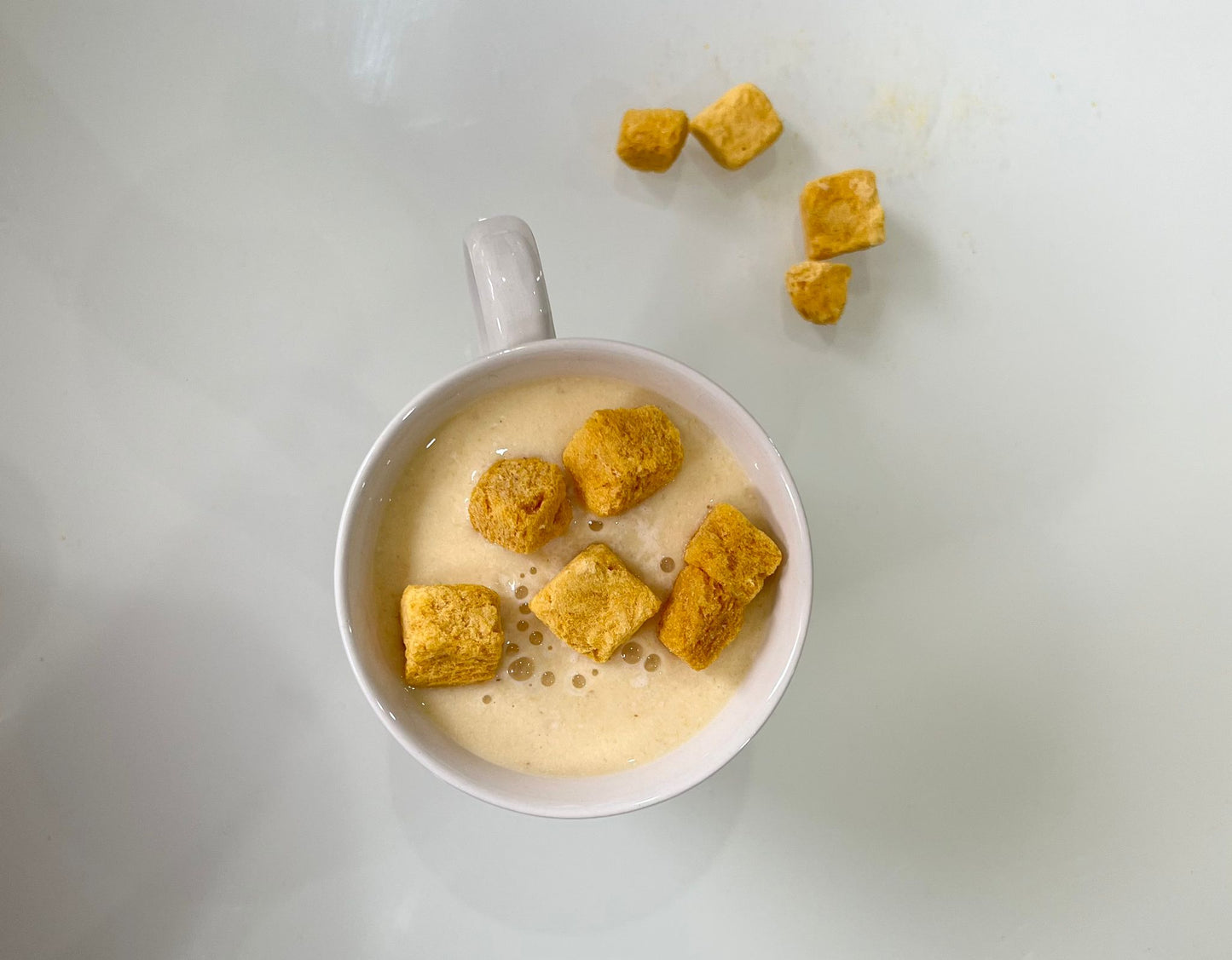 Bowl of cereal with gold-colored cereal pieces on a white background